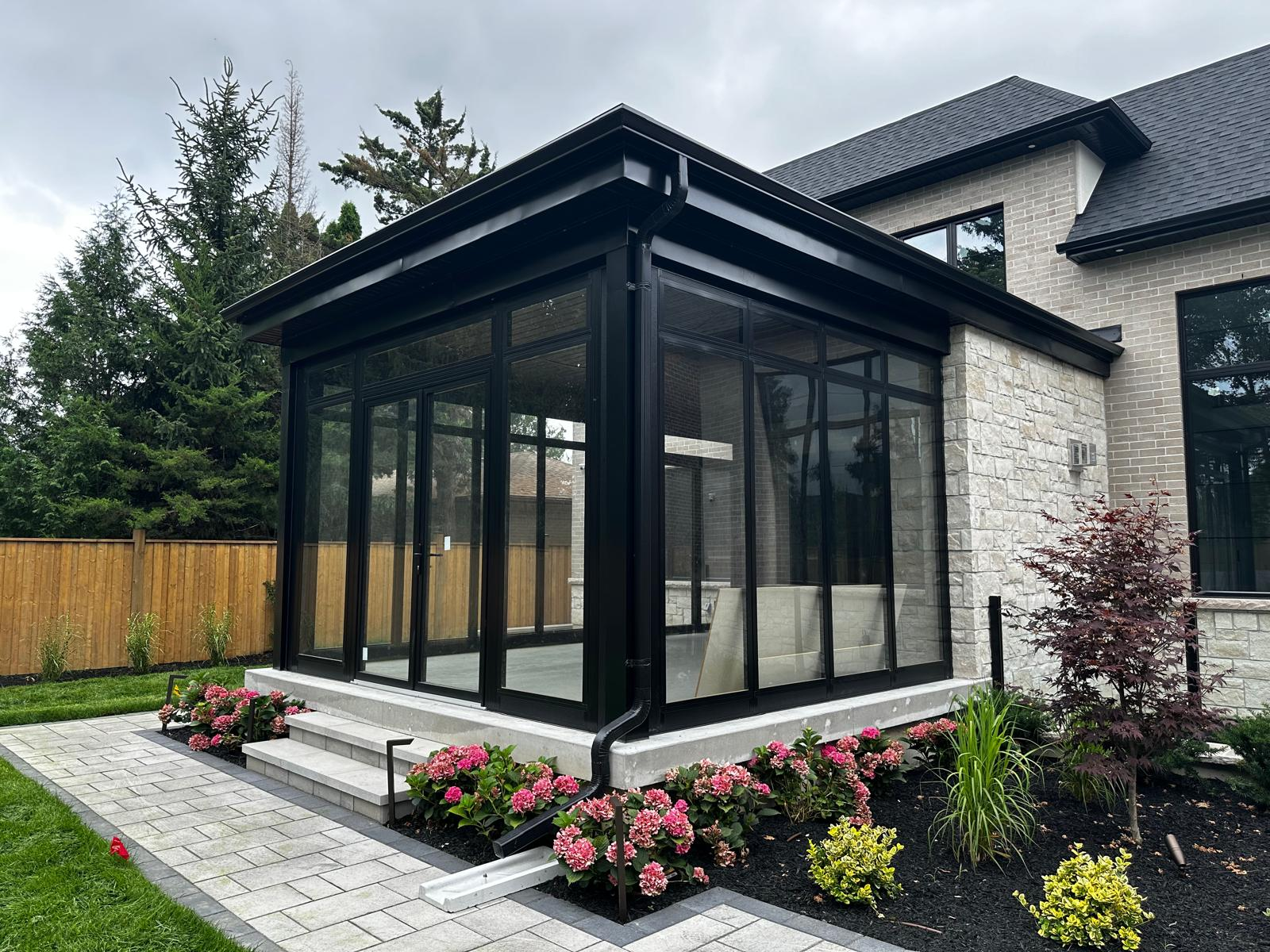 Black-framed Model 300 sunroom with garden landscaping